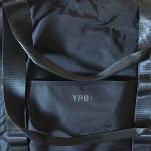 Black tote bag with pocket for suitcase handle